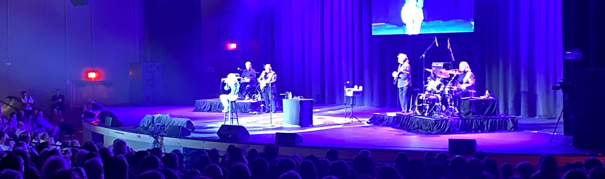 signer on stage in chair washed out by the lights Ames